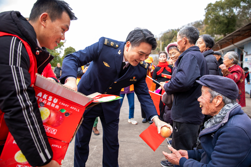 為留守老人分發水果。