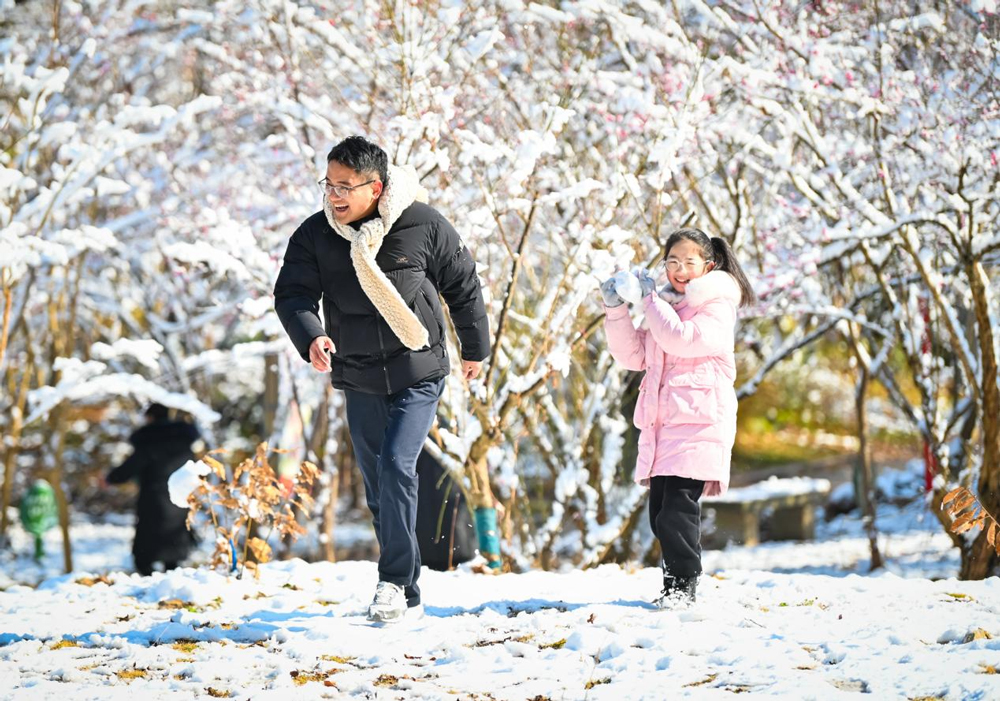 市民走出家門，欣賞難得的雪景。朱偉攝