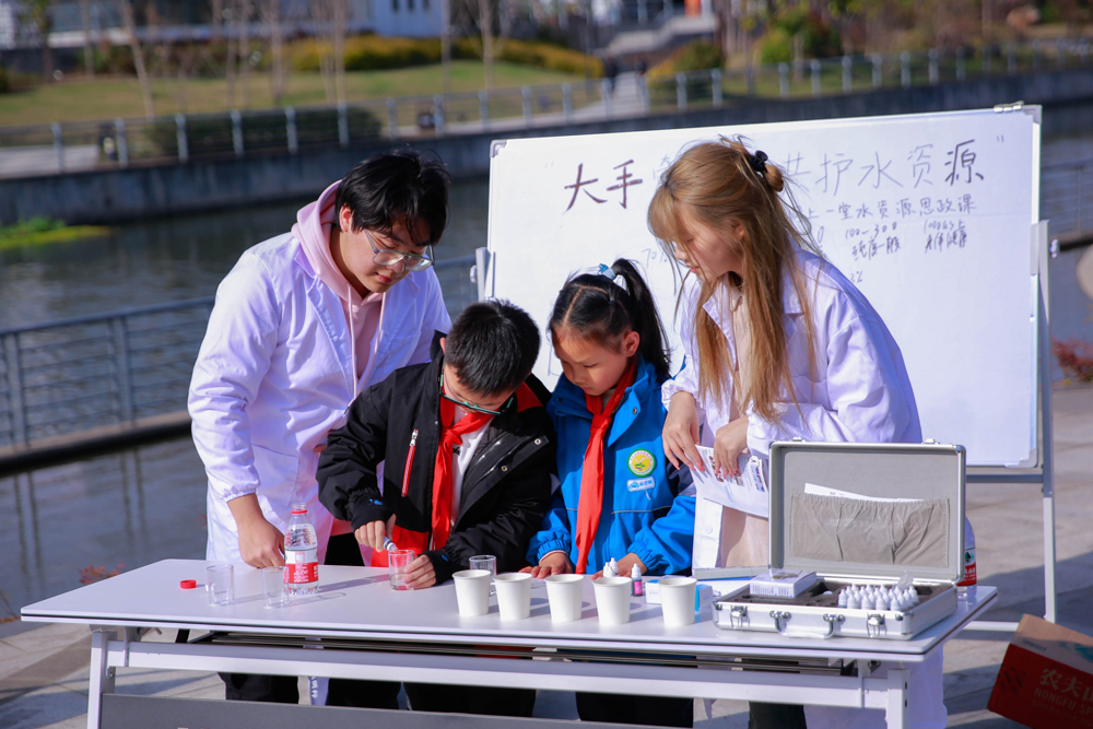 浙江水院經濟與管理工程學院的大學生帶領新灣小學的學生做水質檢測。浙江水院供圖