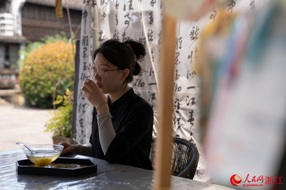 5月26日，浙江省嘉興市月河街，一位年輕女子在喝茶。人民網 陳陸洵攝