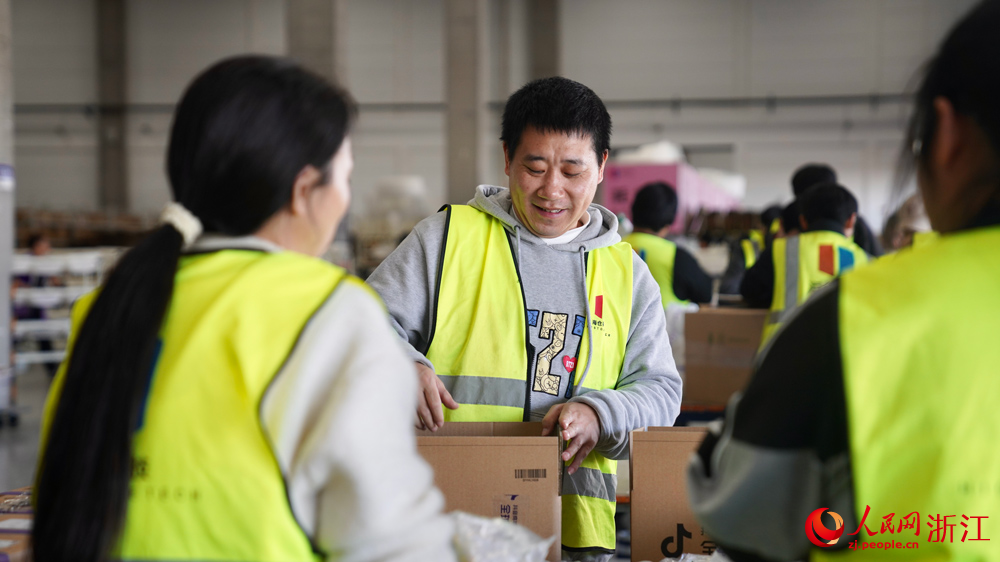 進口商品倉庫中，工作人員正忙著檢驗、分揀、打包進口產品。人民網記者 郭揚攝